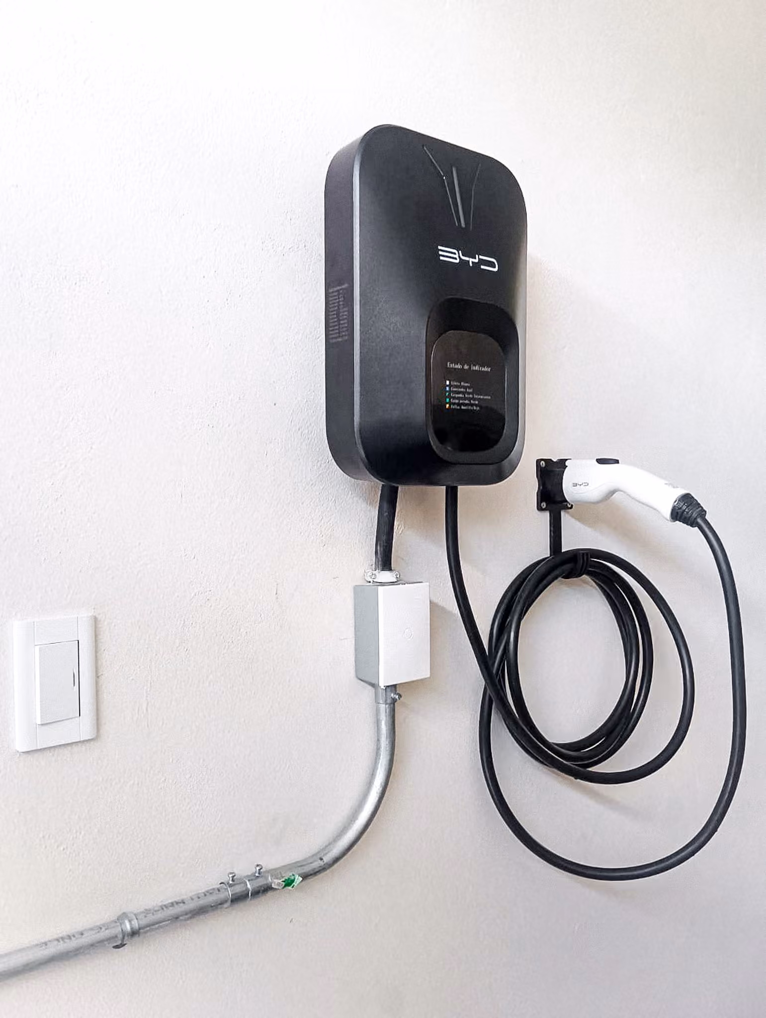 Cargador BYD instalado en interior, con caja de registro y canalización rígida.