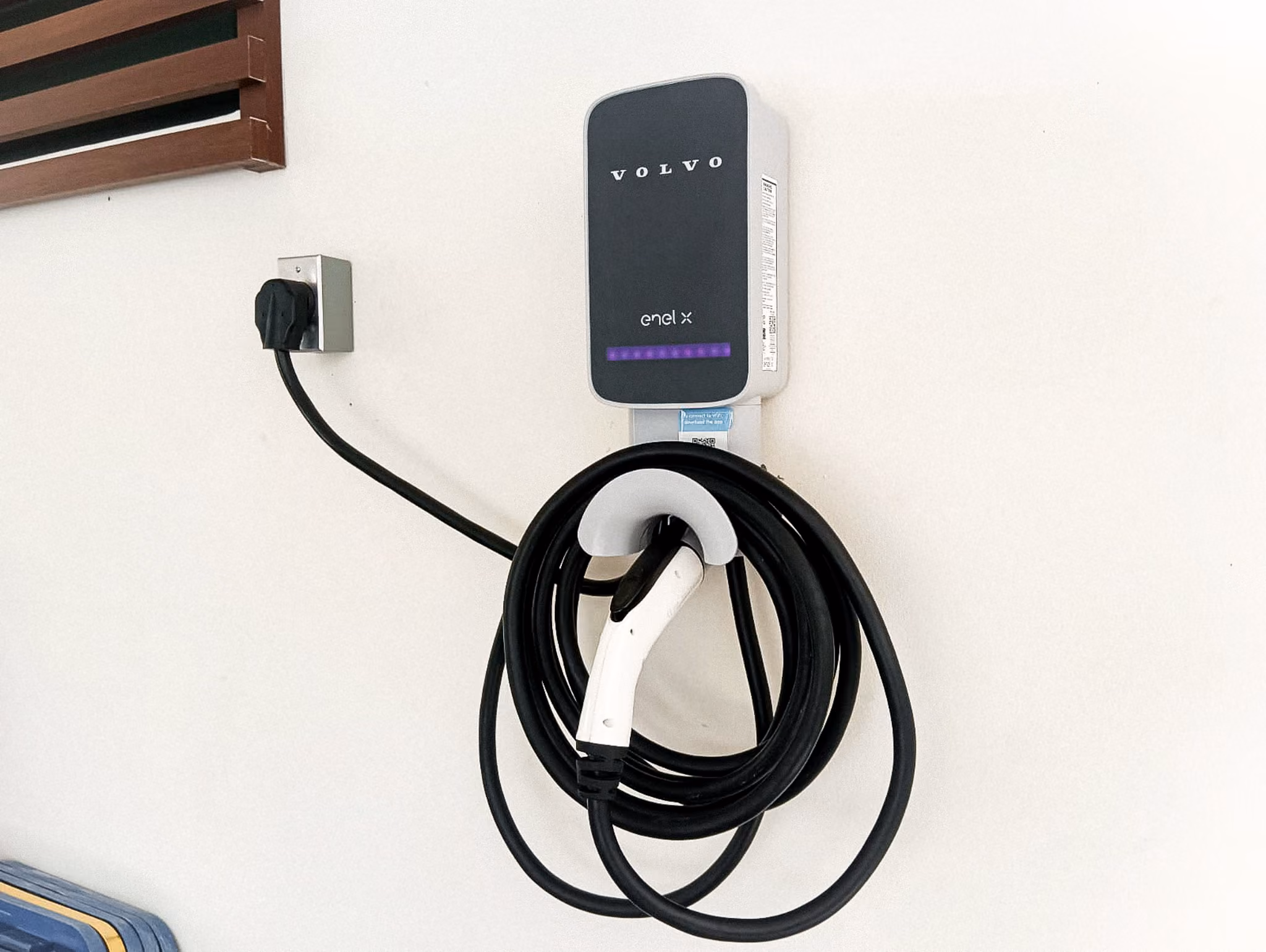 Cargador Volvo Enel X en muro interior, con el cable recogido.
